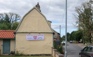 Image of house with a 20's Plenty Banner displayed on the side of the building