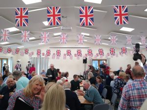 Image of villagers in the hall and Union Jack Bunting