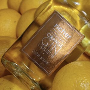 Image of a bottle of richer gin on lemons