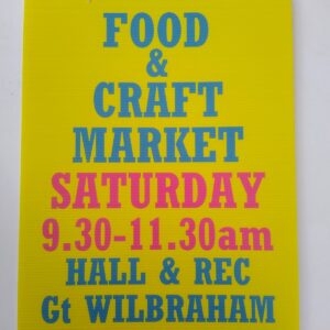 Blue and red text on yellow background of the sign advertising Food and Craft Market, Saturday 