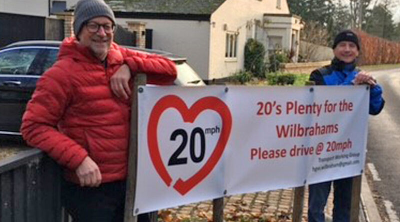 2 men holding a 20's Plenty banner in Great Wilbraham